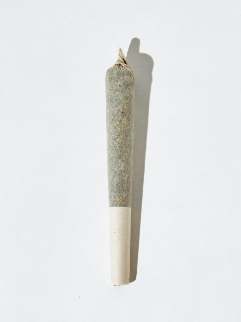 A vertical isolated shot of a marijuana blunt on white background